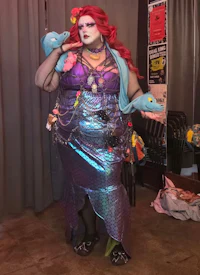 a woman in a mermaid costume is standing in a room